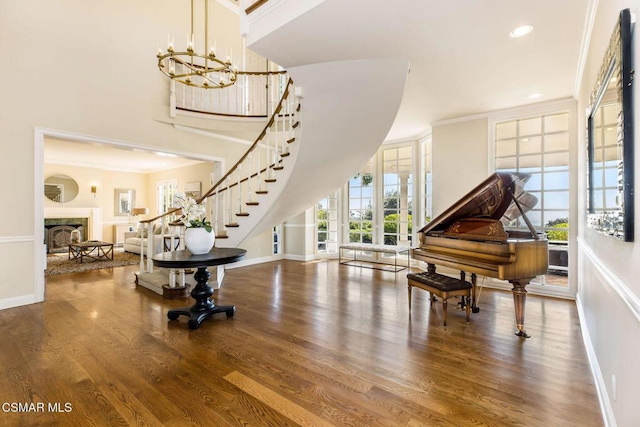 entryway with wood-type flooring, an inviting chandelier, and ornamental molding