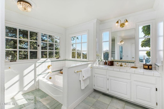 bathroom with a notable chandelier, a washtub, crown molding, and vanity