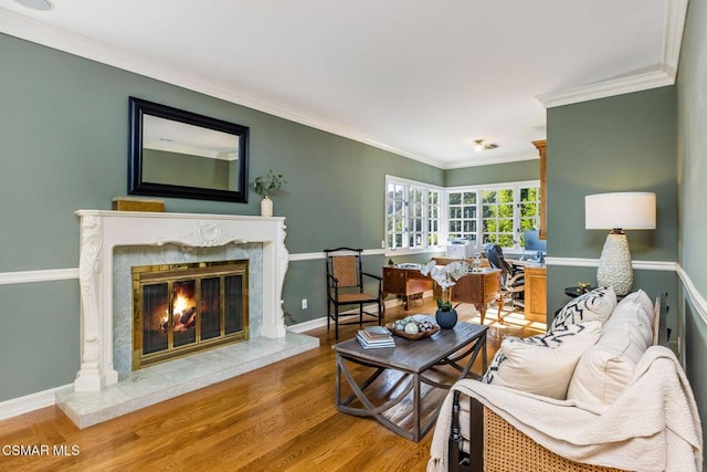 living room with a premium fireplace, ornamental molding, and hardwood / wood-style flooring