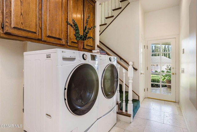 laundry room featuring washer and dryer and cabinets