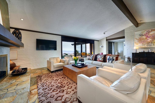 living room featuring brick wall, lofted ceiling with beams, and a textured ceiling