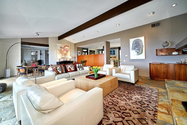 living room with a textured ceiling and lofted ceiling with beams