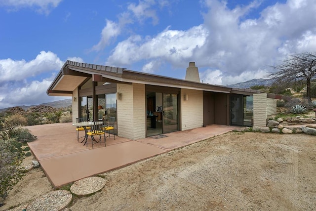 rear view of house with a patio area and a mountain view