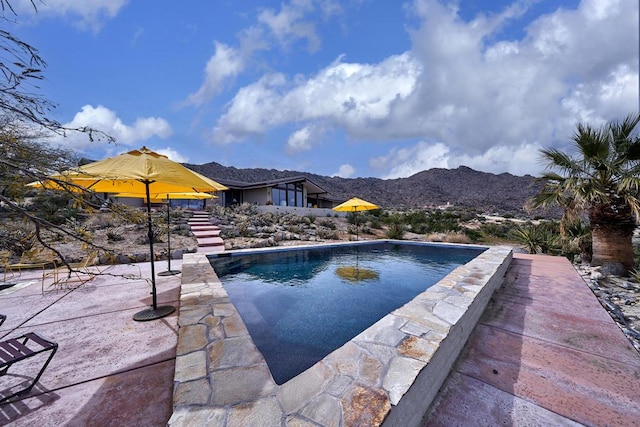 view of pool with a mountain view and a patio area