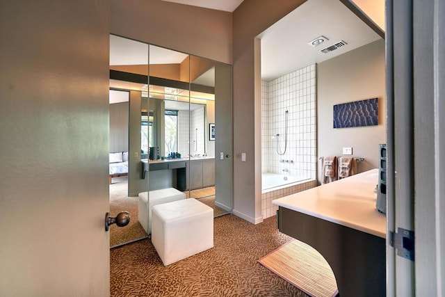 bathroom with vanity and a relaxing tiled tub