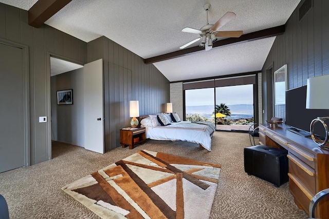 bedroom with ceiling fan, carpet, lofted ceiling with beams, and a textured ceiling