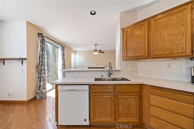 kitchen with ceiling fan, sink, dishwasher, kitchen peninsula, and light wood-type flooring