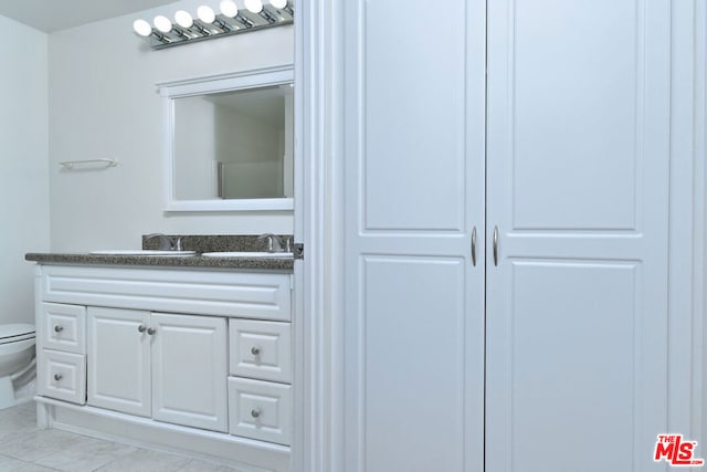 bathroom featuring tile patterned floors, vanity, and toilet