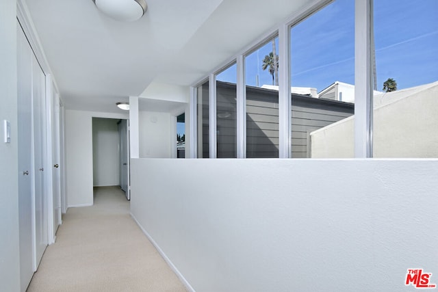 hall with light colored carpet