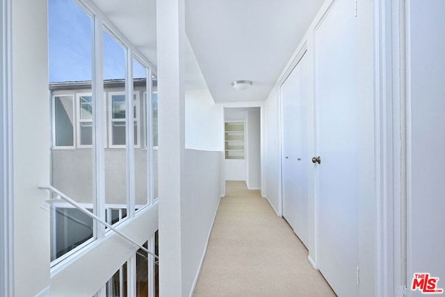 hallway featuring light colored carpet