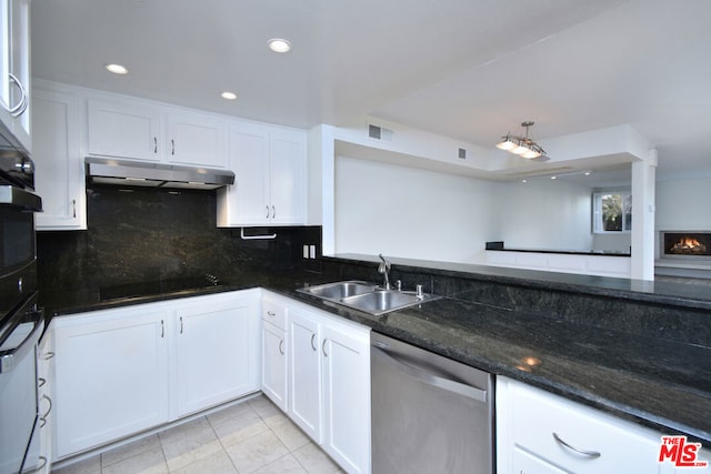 kitchen with dark stone counters, black appliances, white cabinets, sink, and tasteful backsplash