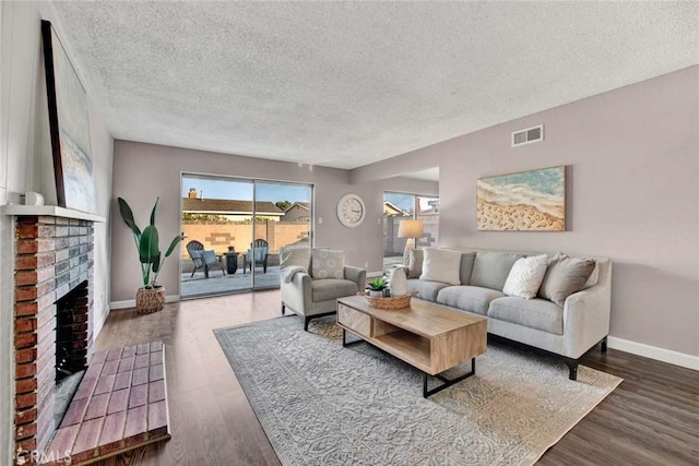 living room with a textured ceiling, a fireplace, and dark wood-type flooring