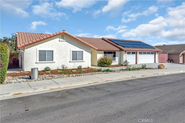 view of front of house featuring a garage and solar panels