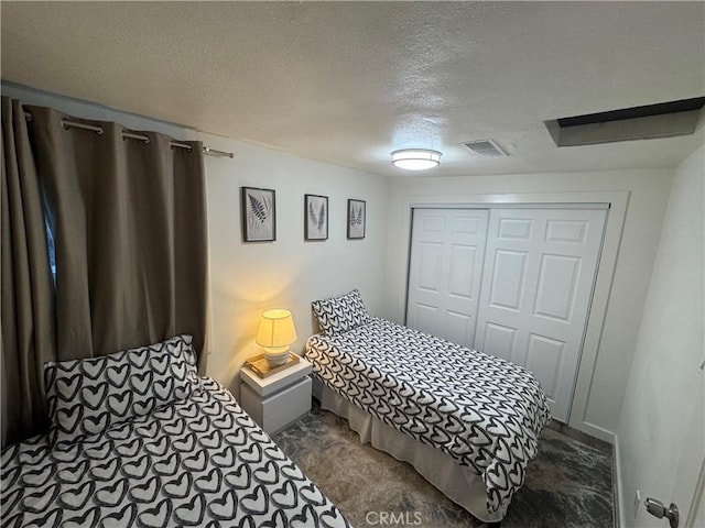 carpeted bedroom with a closet and a textured ceiling