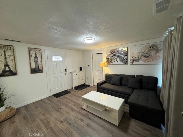 living room with hardwood / wood-style flooring and a textured ceiling