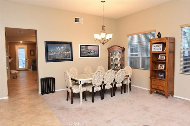 dining room featuring a notable chandelier and light carpet