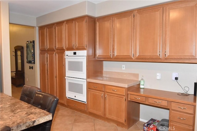 kitchen featuring white double oven and light tile patterned flooring