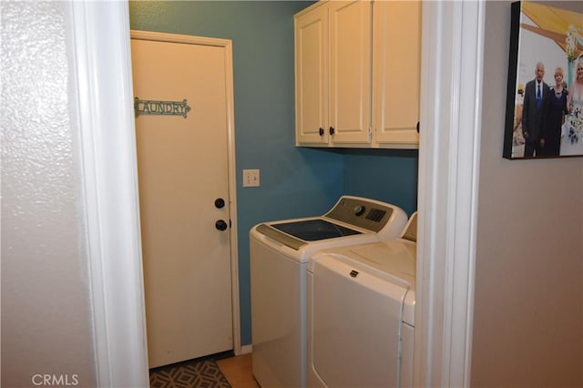 laundry area with cabinets and washing machine and clothes dryer