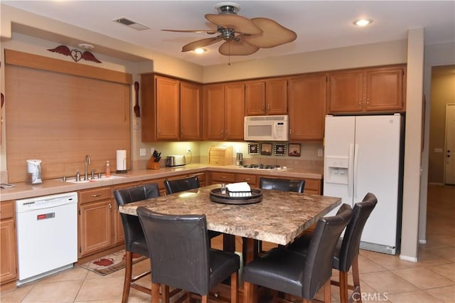 kitchen with a center island, white appliances, sink, ceiling fan, and light tile patterned floors