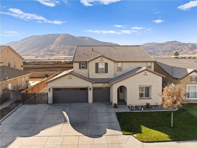 mediterranean / spanish home with a mountain view, a front yard, and a garage