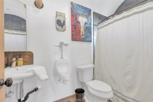 bathroom with curtained shower and toilet