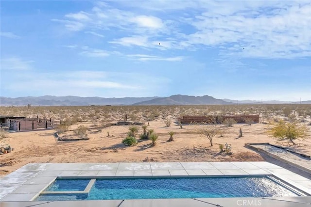 view of pool with a mountain view and an in ground hot tub