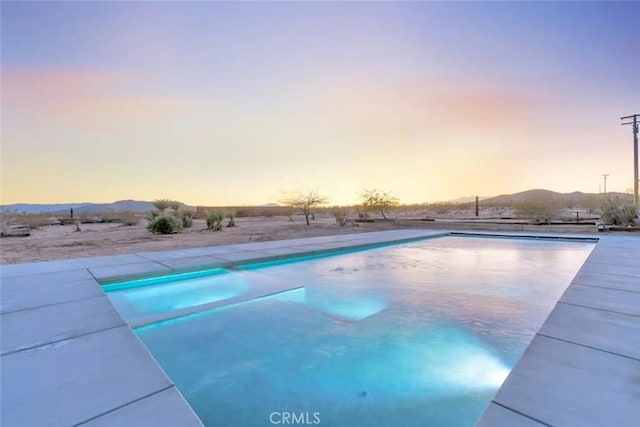 pool at dusk with a mountain view