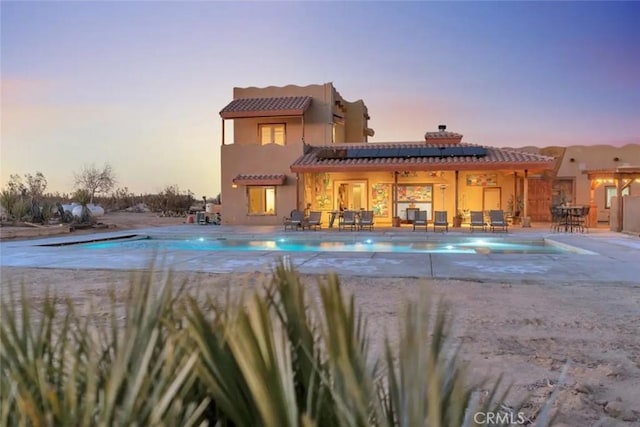 pool at dusk with a patio