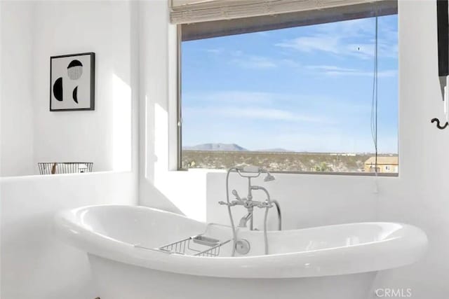 bathroom featuring a mountain view and a bath