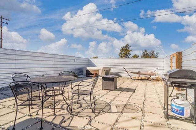 view of patio with area for grilling and an outdoor fire pit