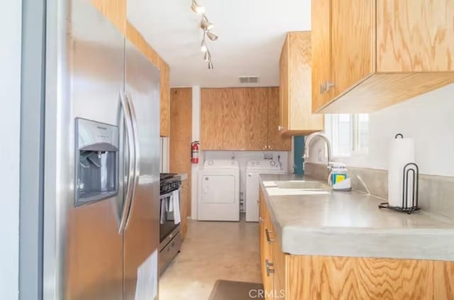 kitchen featuring sink, stainless steel appliances, and washing machine and clothes dryer