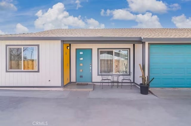 single story home featuring a garage and a patio area