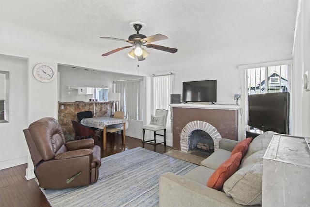 living room with a fireplace, ceiling fan, and hardwood / wood-style floors