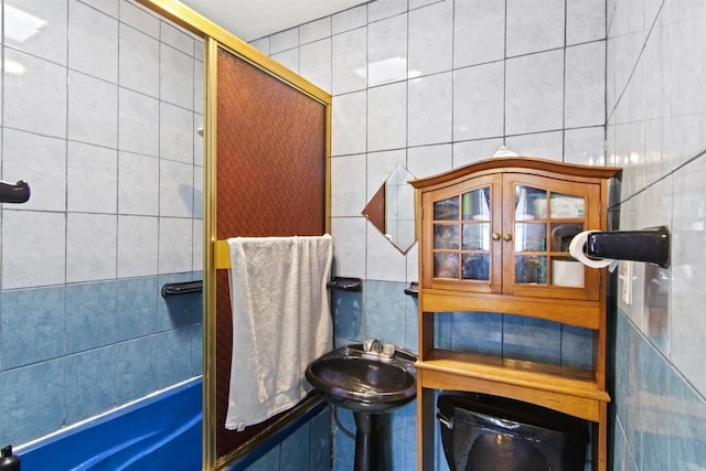 bathroom featuring toilet, sink, and tile walls