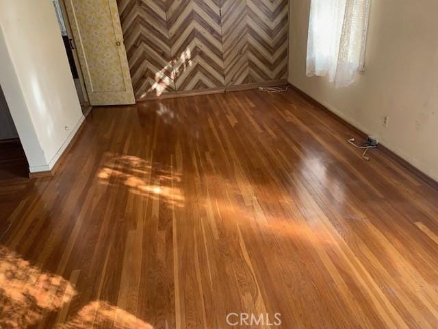 unfurnished room with dark wood-type flooring