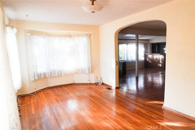 empty room featuring a textured ceiling and hardwood / wood-style flooring