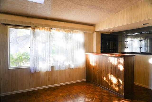 bar featuring wood walls, dark parquet flooring, and a wealth of natural light