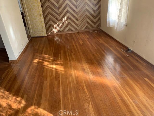 spare room featuring wood finished floors and baseboards