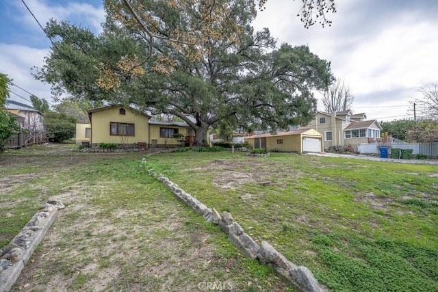 view of yard with an attached garage and fence
