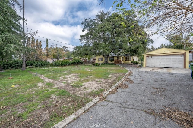view of front of property featuring a detached garage, an outbuilding, and a front lawn