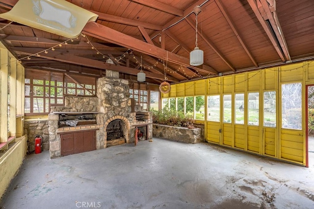 unfurnished sunroom featuring a stone fireplace and vaulted ceiling