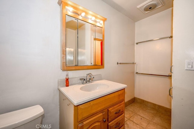 bathroom with visible vents, toilet, vanity, and baseboards