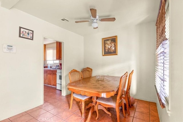 dining space with ceiling fan, plenty of natural light, and light tile patterned floors