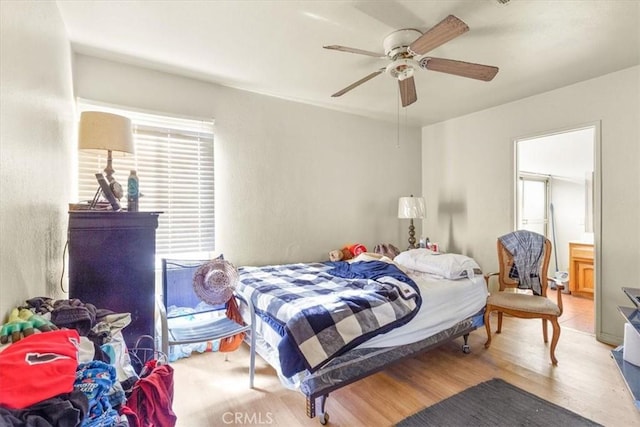 bedroom featuring ceiling fan, light hardwood / wood-style floors, and ensuite bath