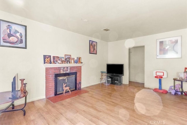 living room featuring a fireplace and light wood-type flooring