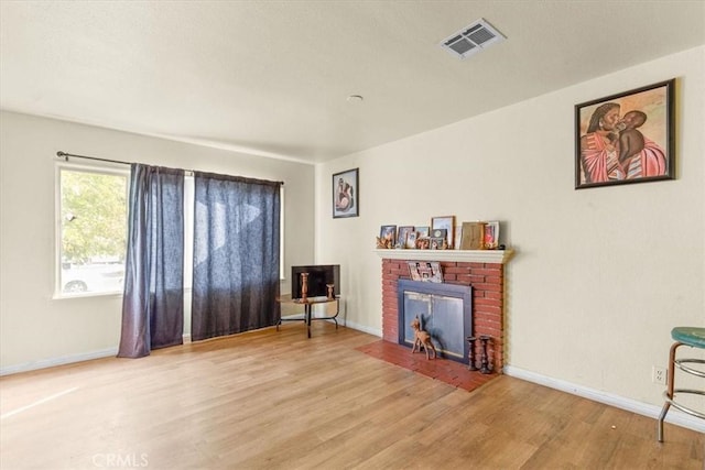 living area with a fireplace and wood-type flooring