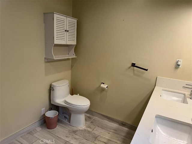 bathroom with vanity, wood-type flooring, and toilet