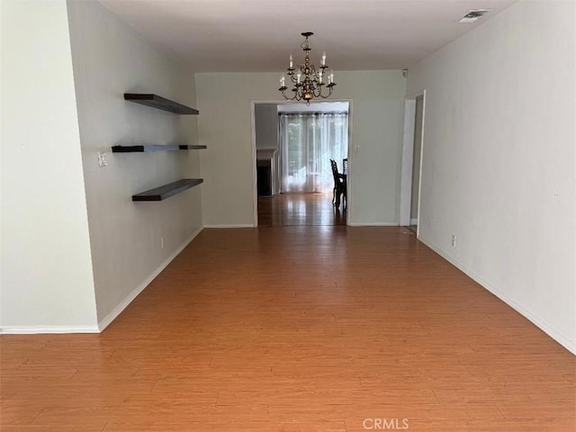 hallway with a chandelier and light wood-type flooring