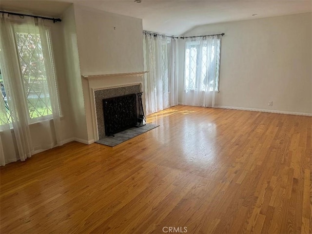 unfurnished living room featuring light wood-type flooring and a wealth of natural light