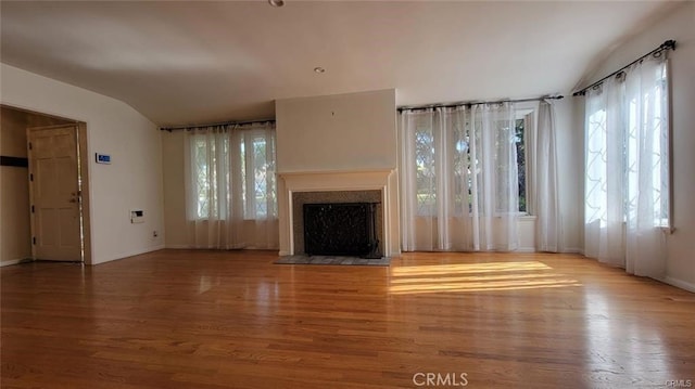 unfurnished living room featuring light wood-type flooring and vaulted ceiling